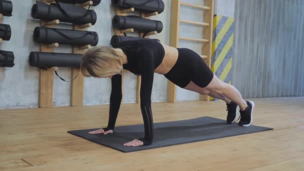 Frauen üben Plankenlauf im Fitnessstudio. Frauen trainieren Bauch, machen Fitnesstraining in Innenräumen, Bauchmuskeltraining, professionelle Trainingsprogramme, Selbsttraining bauen Körper auf - Filmmaterial, Video