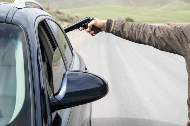 мужчина угрожает водителю пистолетом - Фото, изображение