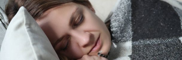 Портрет женщины, спящей под одеялом на диване - Фото, изображение