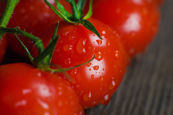 Ripe delicious red cherry tomatoes close-up on a wooden background - Foto, afbeelding