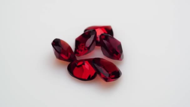 回転テーブルの上の白い背景にある天然の赤いガーネットの宝石 - 映像、動画