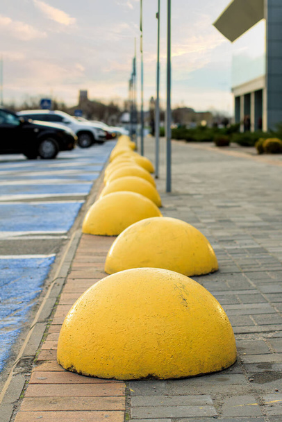 Hemisferios amarillos anti-estacionamiento en la acera cerca del centro comercial - Foto, imagen