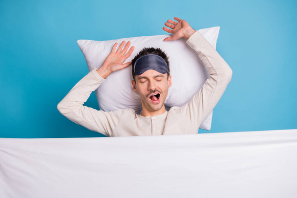Photo portrait top above high angle view of guy waking up in bed stretching yawning isolated on vivid blue colored background - Zdjęcie, obraz
