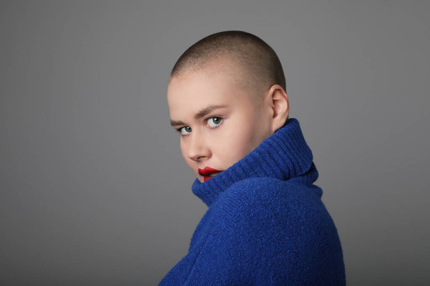 Headshot of woman with shaved hairstyle, posing over grey background. - Photo, Image