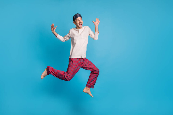Full length photo portrait of dreamy man screaming jumping up looking at blank space isolated on vivid blue colored background - Foto, Imagem
