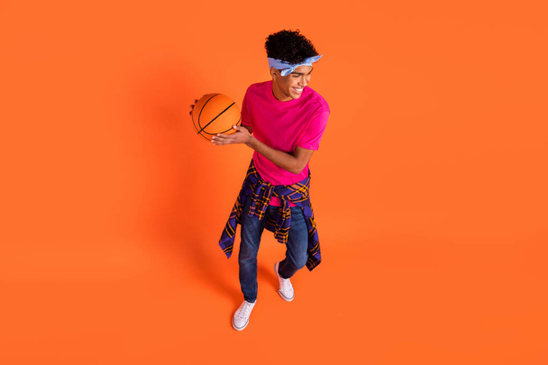 High angle view photo young guy in stylish clothes playing basketball laughing isolated on bright orange color background - Valokuva, kuva