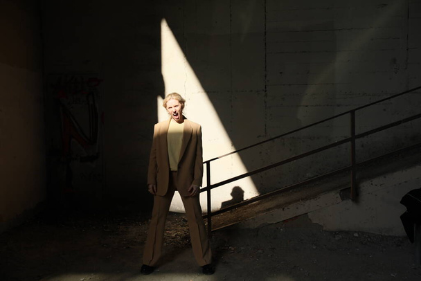 Portrait of beautiful young model wearing beige suit, posing outdoor. - Fotografie, Obrázek