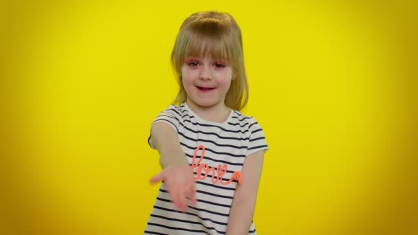 Μικρό ξανθό κοριτσάκι κορίτσι που δείχνει φιλόξενη χειρονομία με τα χέρια, να ζητήσει να ενταχθούν, γνέφοντας για να έρθει - Πλάνα, βίντεο