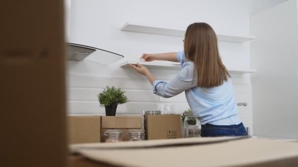 Женщина вытирает кухню после переезда в новую квартиру. - Кадры, видео