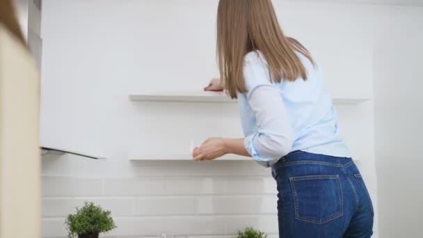 Vrouw veegt de keuken na het verhuizen naar een nieuw appartement. - Video