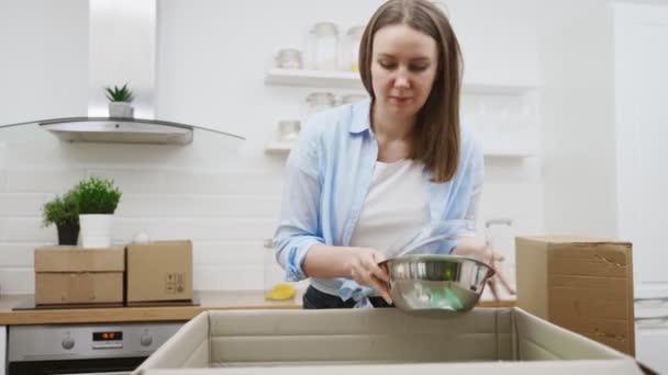 Femme arrange ustensiles de cuisine après le déménagement dans un nouvel appartement. - Séquence, vidéo