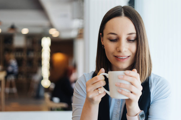 Muotokuva nuori nainen juo kahvia pöydässä kahvilassa - Valokuva, kuva