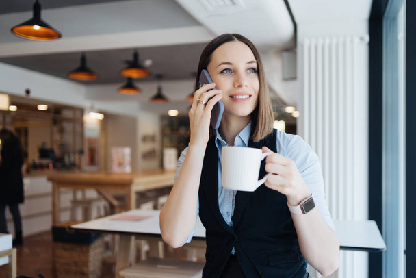 Καυκάσια όμορφη γυναίκα χρησιμοποιώντας έξυπνο τηλέφωνο για τις επιχειρήσεις - Φωτογραφία, εικόνα