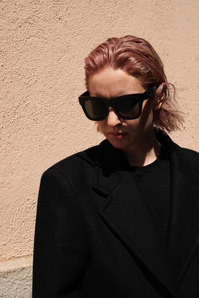 Young woman with pinkish hair, wearing sunglasses looking aside. - Fotografie, Obrázek