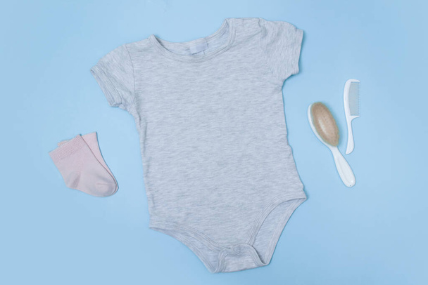 Flat lay mock up grey baby bodysuit on a blue background. Your design or logo placement - Photo, Image