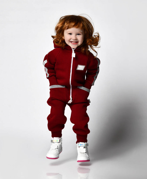 Cute red-haired girl in a comfortable tracksuit - 写真・画像