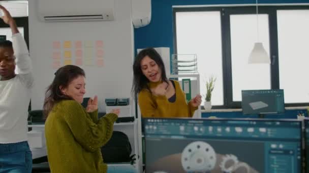 Entusiasta diversi ingegneri donne che ballano in ufficio aziendale - Filmati, video