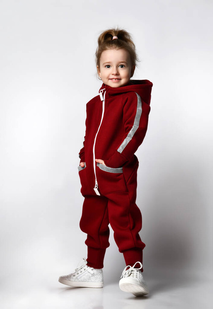 Cute little preschooler girl in tracksuit sportswear studio portrait - Valokuva, kuva