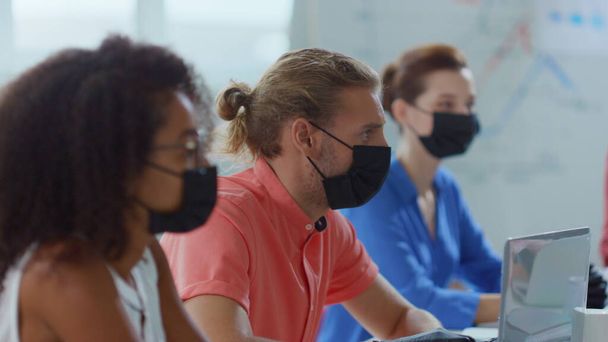 Persone mascherate che lavorano in ufficio. Business team indossando guanti e maschera in sala riunioni - Foto, immagini