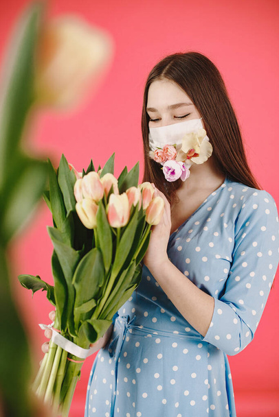 Girl in a mask with flowers on a red background - Foto, afbeelding