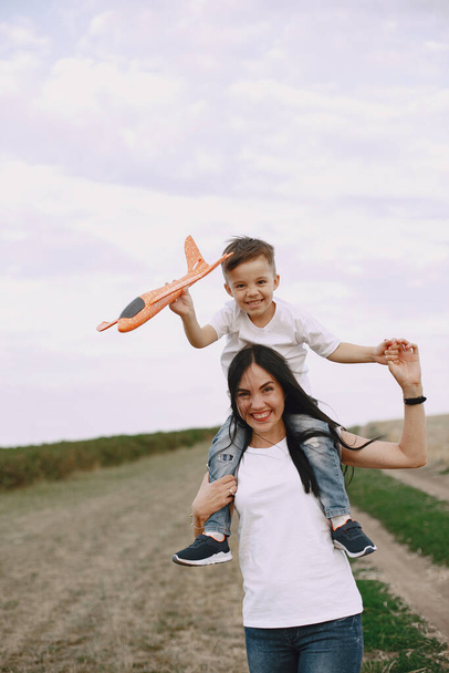 母とともに小さな息子遊びとともにおもちゃの飛行機 - 写真・画像