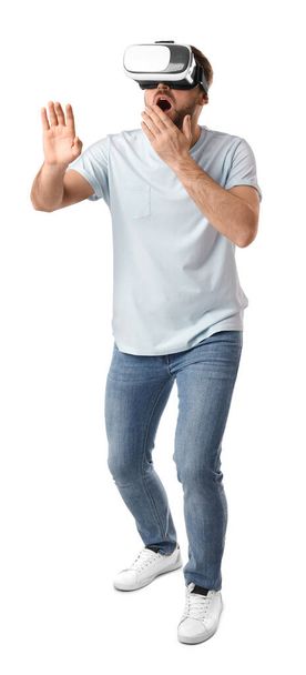 Emotional man using virtual reality headset on white background - Valokuva, kuva