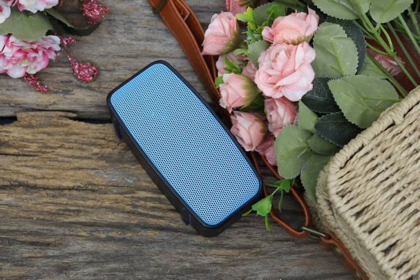 Blue bluetooth speaker sound audio and rattan bag with pink rose - Photo, Image