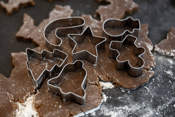 Assortment of Tiny Cookie Cutters Pressed into Gingerbread Dough on floured surface - 写真・画像