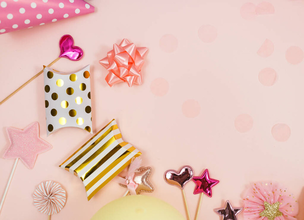 Achtergrond voor een gelukkige verjaardag of feest. Groep van gekleurde ballonnen, confetti, kaarsen, linten op pastel roze achtergrond. Mockup met kopieerruimte, een plek voor tekst - Foto, afbeelding