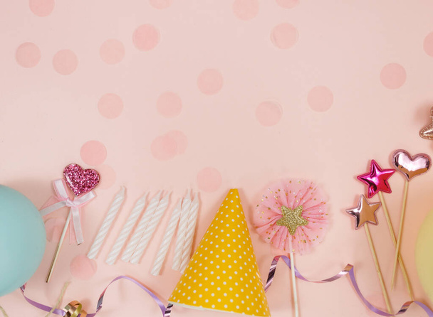 Background for happy birthday celebration or party. Group of colored balloons, confetti, candles, ribbons on pastel pink background. Mockup with copy space, a place for text - Photo, Image
