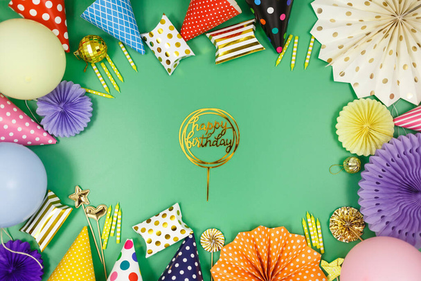 Background for happy birthday celebration or party. Group of colored balloons, confetti, candles, ribbons on green pastel background. Mock up with copy space, a place for text - Photo, Image