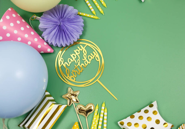 Background for happy birthday celebration or party. Group of colored balloons , confetti, candles, ribbons on green pastel background. Mock up with copy space, place for text - Fotó, kép