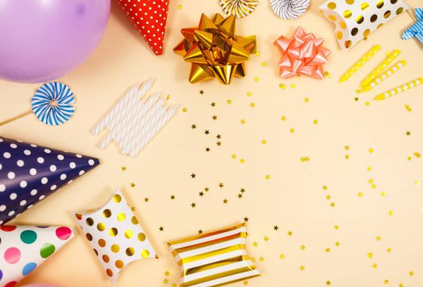 Fondo para la celebración feliz cumpleaños o fiesta. Grupo de globos de colores, confeti, velas, cintas sobre fondo beige pastel. Prepárate con espacio de copia, un lugar para el texto - Foto, Imagen