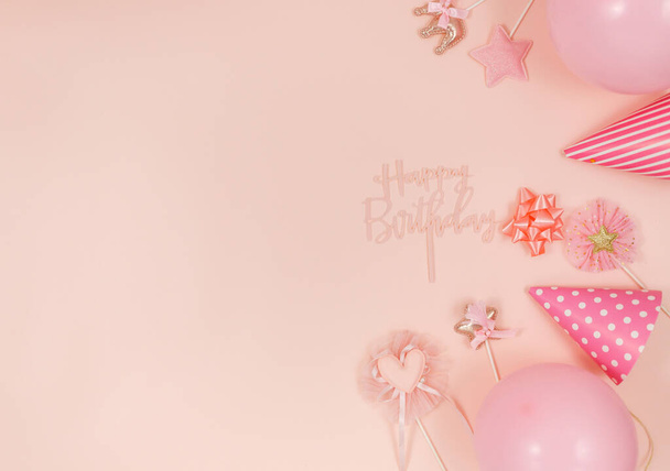 Background for happy birthday celebration or party. Group of colored balloons, confetti, candles, ribbons on pastel pink background. Mockup with copy space, a place for text - 写真・画像