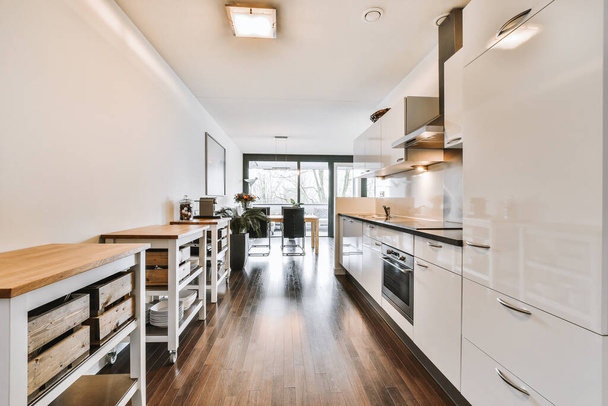 Modern kitchen near dining room in flat - Photo, Image