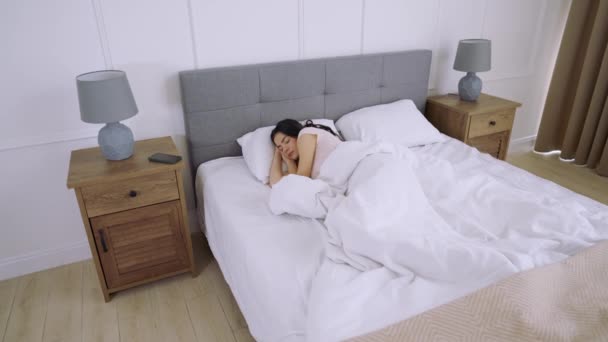Jonge vrouw slaapt in comfortabel bed - Video