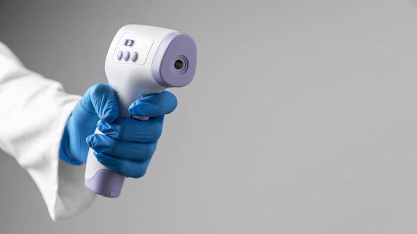 guantes médicos que sostienen el termómetro con espacio para copias. Resolución y alta calidad hermosa foto - Foto, imagen
