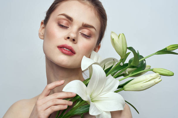 kobieta z białymi kwiatami na szarym tle  - Zdjęcie, obraz