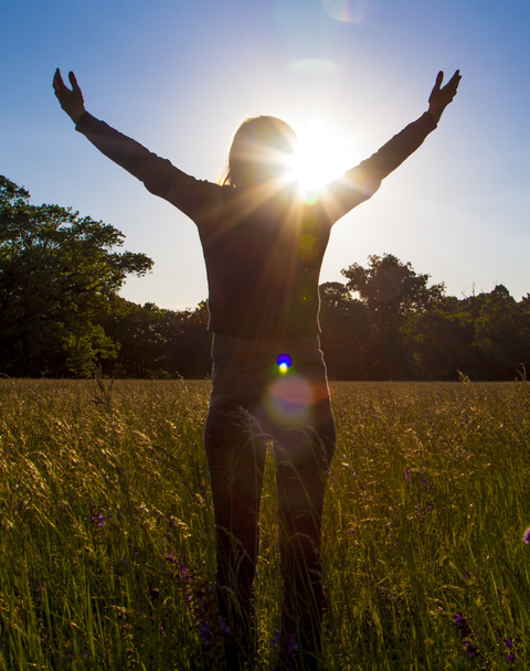 Молодая девушка протягивает руки с радостью и вдохновением лицом к солнцу, приветствие солнца
 - Фото, изображение