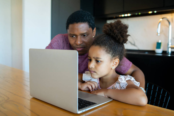 A father helping his daughter with homeschool. - Foto, Bild