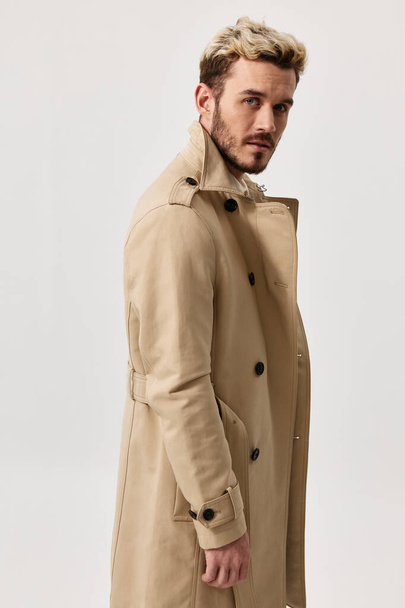 portrait of a man in a beige coat fashionable hairstyle light background Copy Space - Foto, immagini