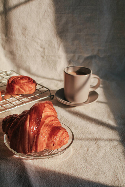 Coffee with croissant so delicious under sunlight. Perfect breakfast in the morning. - Foto, Imagen