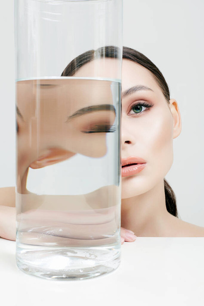 красивая девушка за стеклом с водой. чистая кожа молодая женщина. Портрет красавицы - Фото, изображение