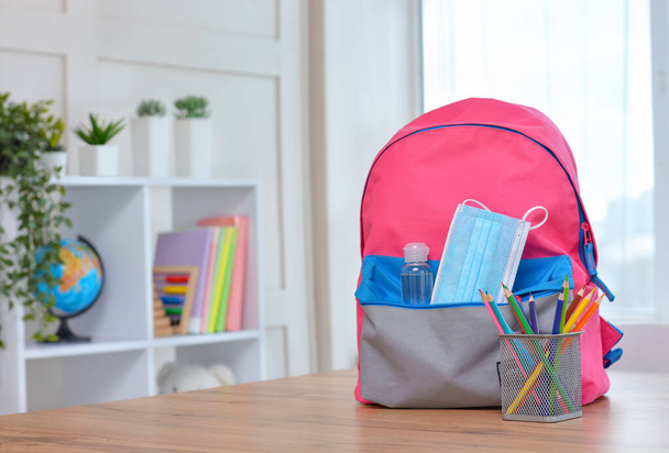 Backpack with school supplies and sanitizer and medical protective mask.Back to school and kindergarten after coronavirus. the beginning of the school season.Safe learning. - Photo, Image