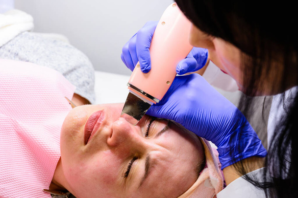 Kosteuttava kasvot ja poistamalla keratinoitu vanha iho, kosmetologi käyttää ultraääni mikrovärähtelyjä. uusi - Valokuva, kuva