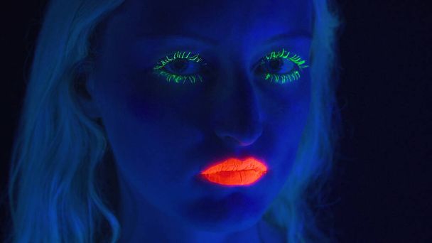 Mladá dívka s jasným make-upem v ultrafialovém světle - Fotografie, Obrázek