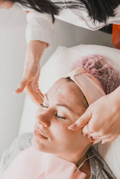 Femme heureuse et détendue sur les procédures de cosmétologie, massage et application de crème pour le visage. nouveau - Photo, image