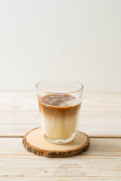 Dirty coffee glass, cold milk topped with hot espresso coffee shot - Фото, изображение