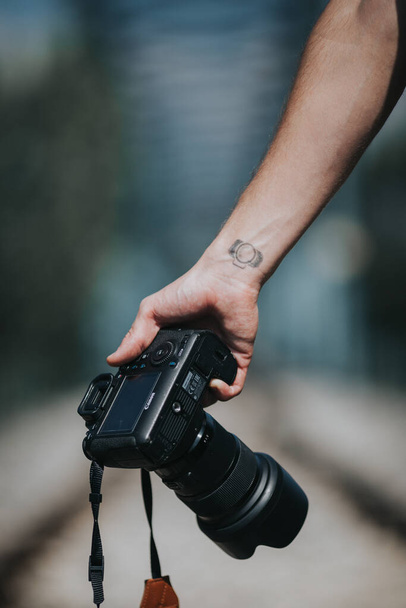 BRCKO, BOSNIA I HERZEGOVINA - Kwi 17, 2021: Młody mężczyzna z tatuażem z aparatem Canon i obiektywem Sigma - Zdjęcie, obraz