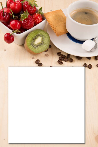 クッキーと砂糖とコーヒーカップは、テキストのための空白のシート紙と赤い果実と木製のテーブルの上に横たわってフードモックアップ空の白いカード紙招待状レシピ - 写真・画像